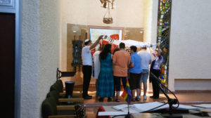 Rabbi Gabby and Rabbi Na'ama give a blessing under a prayer shawl